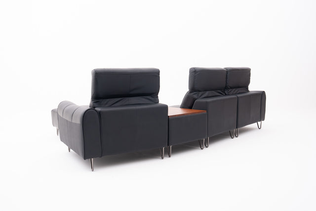 Black Contemporary Modular Sofa with Adjustable Headrests, Integrated Side Table & Matching Ottoman.
