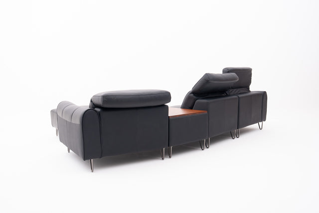 Black Contemporary Modular Sofa with Adjustable Headrests, Integrated Side Table & Matching Ottoman.