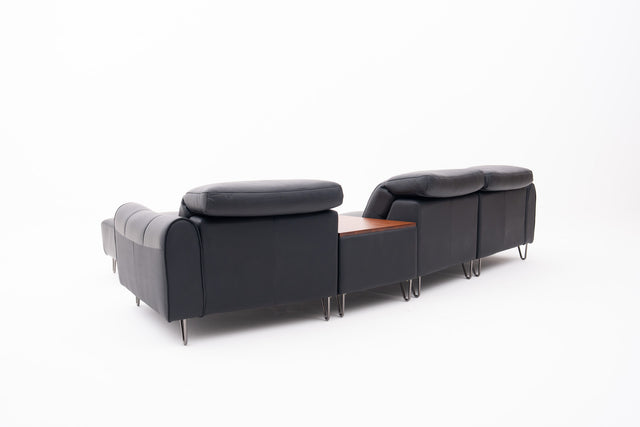 Black Contemporary Modular Sofa with Adjustable Headrests, Integrated Side Table & Matching Ottoman.